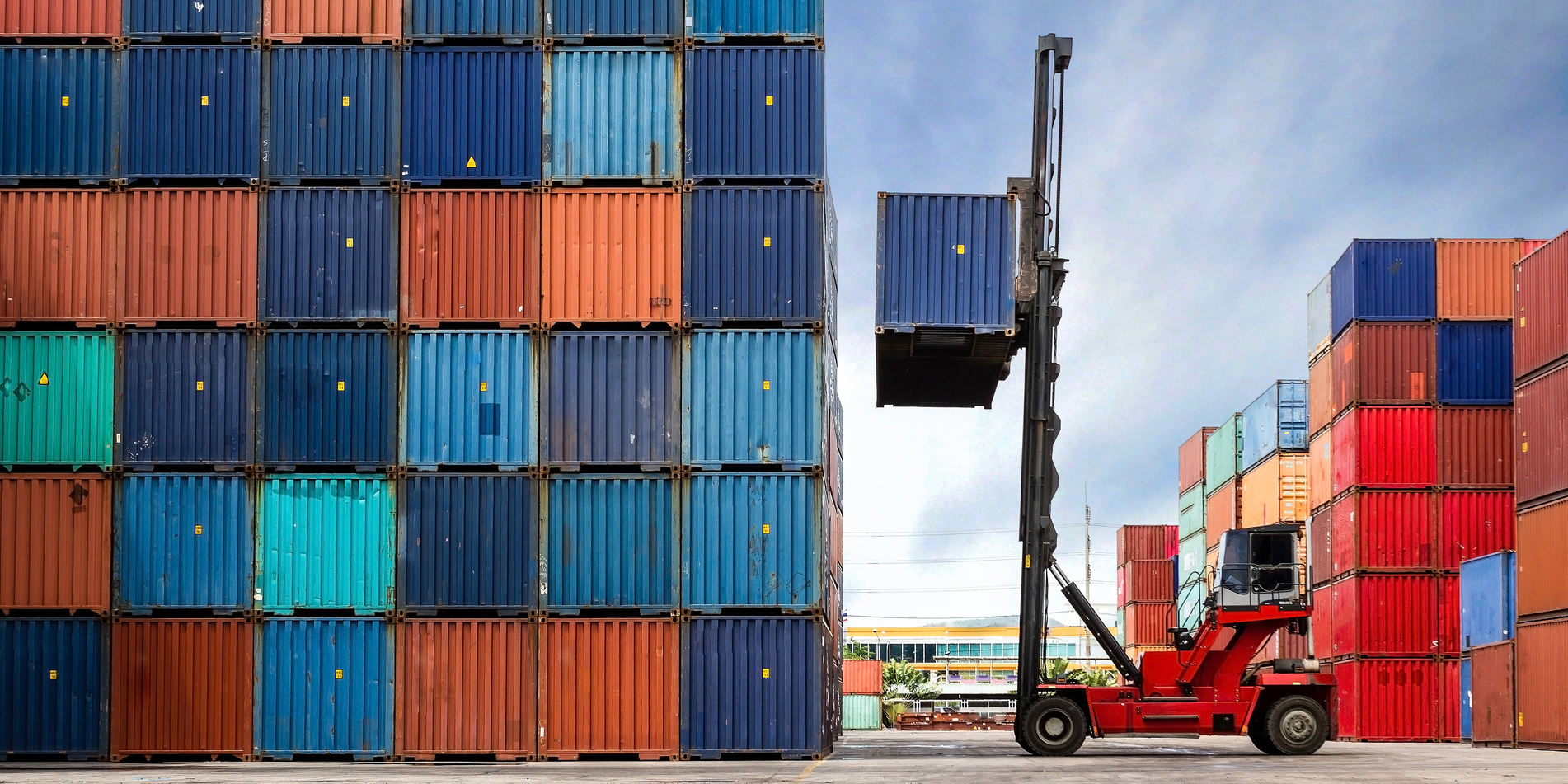 Fork lift stacking a shipping container.