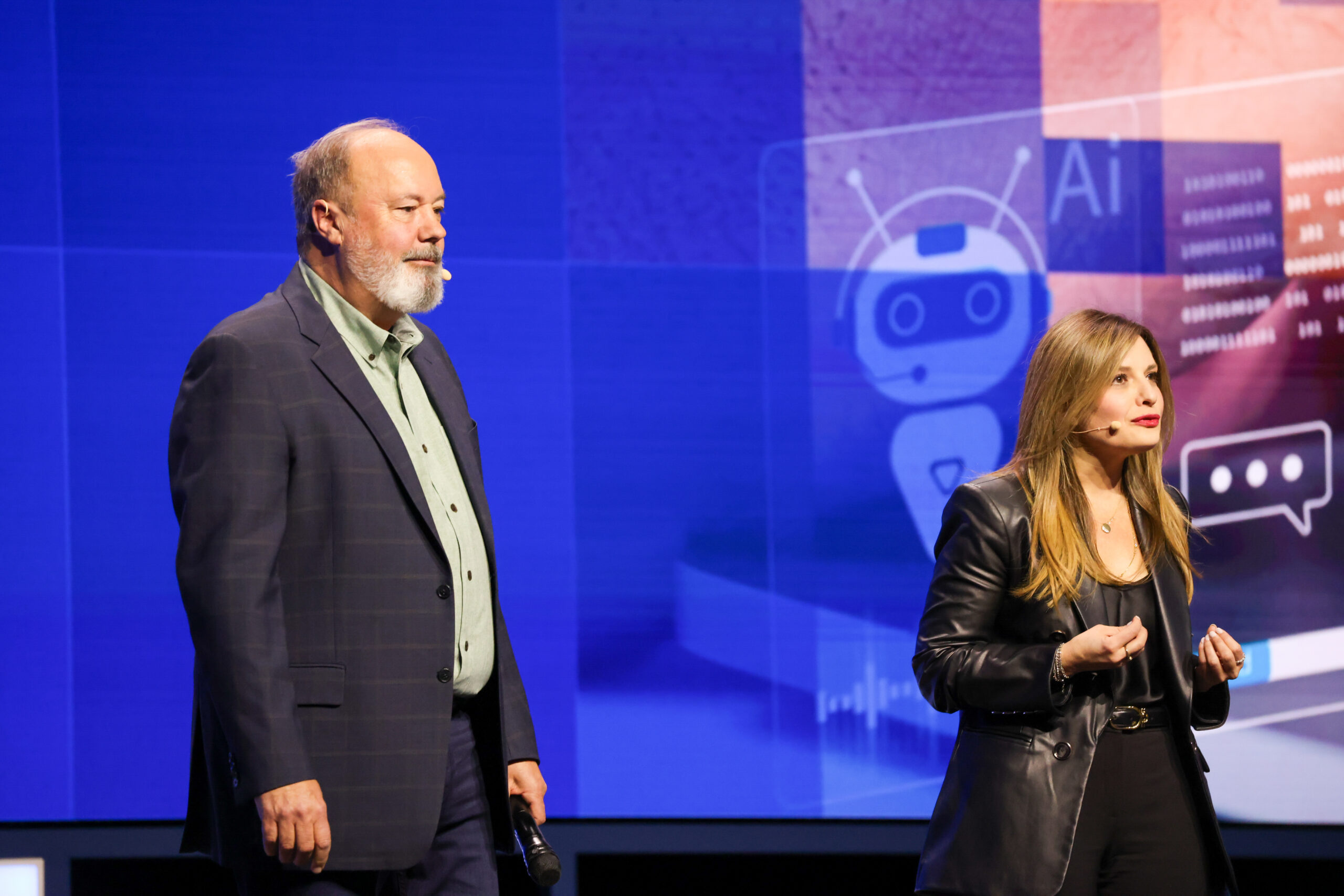 Dounia Senawi and Jim Johnson on stage at Intel Vision in front of an AI graphic.