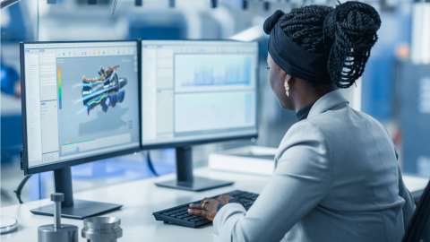 Woman using PC with two monitors