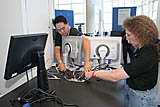 Intel sponsor/exhibitor booth staff members Grant Kobayasahi, cq, left, and Lori Janz, cq, right, set up mobile systems for the Advanced Technology Zone featuring Intel Virtualization Technology on Level Two at Moscone West in San Francisco, Calif., on Monday, August 22, 2005. (Photo by Intel Press Relations)